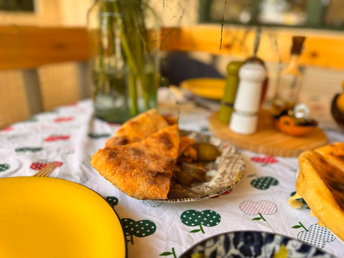 A laid Kakhetian table with khachapuri, pickles and wine